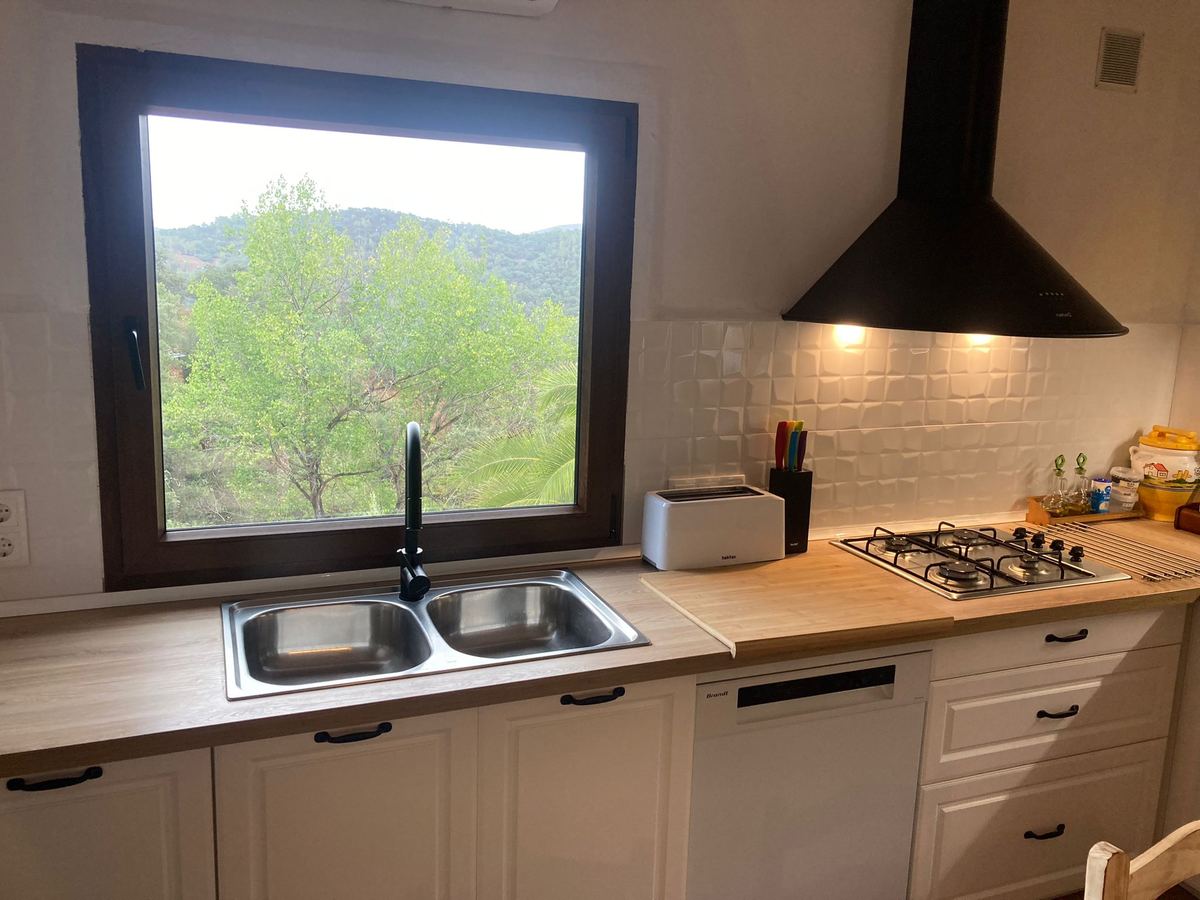 Cocina con fregadero, cocina de gas y ventana con vistas a la sierra